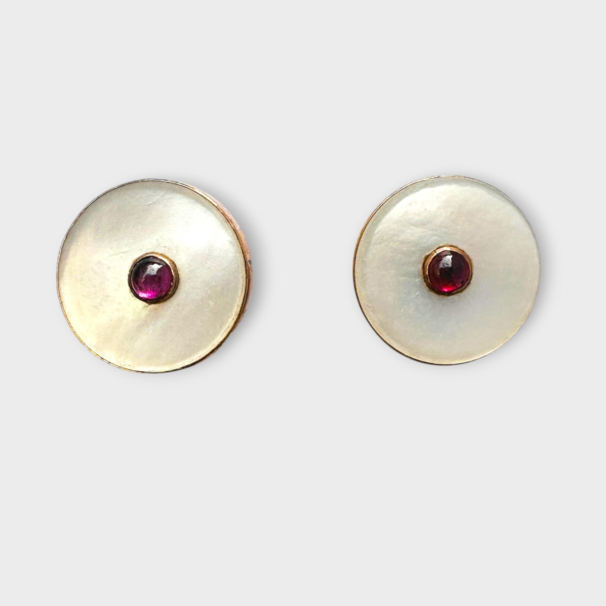Art Deco 9ct gold earrings with ruby and mother of pearl on grey background.