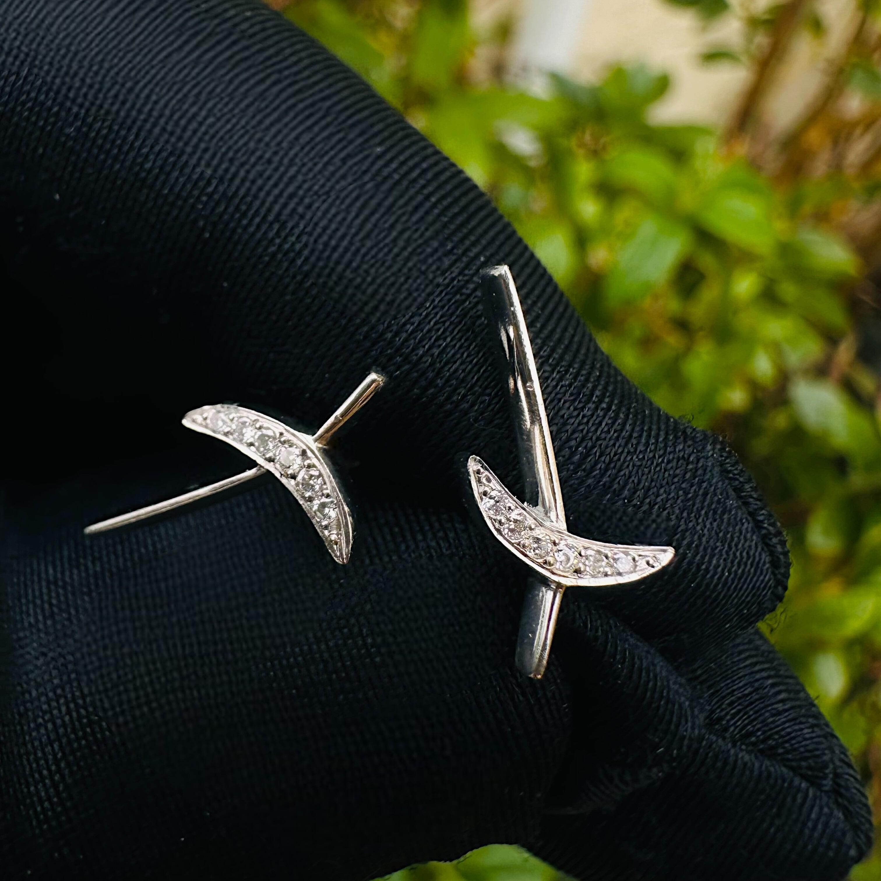 Platinum & Diamond Kiss Earrings held in black glove in garden