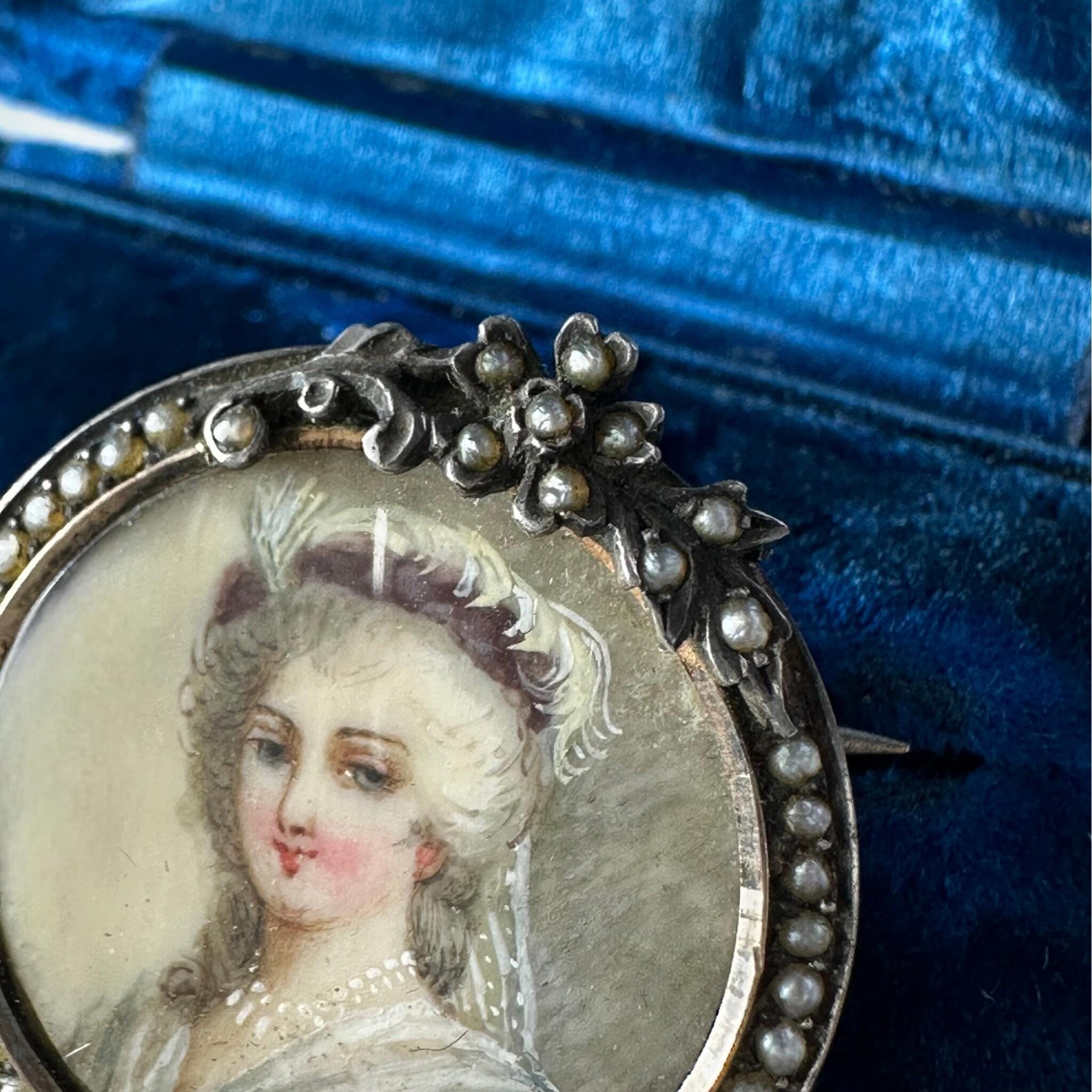 close up of Georgian Marie Antoinette & Silver Seed Pearl Portrait Brooch displayed on blue antique box