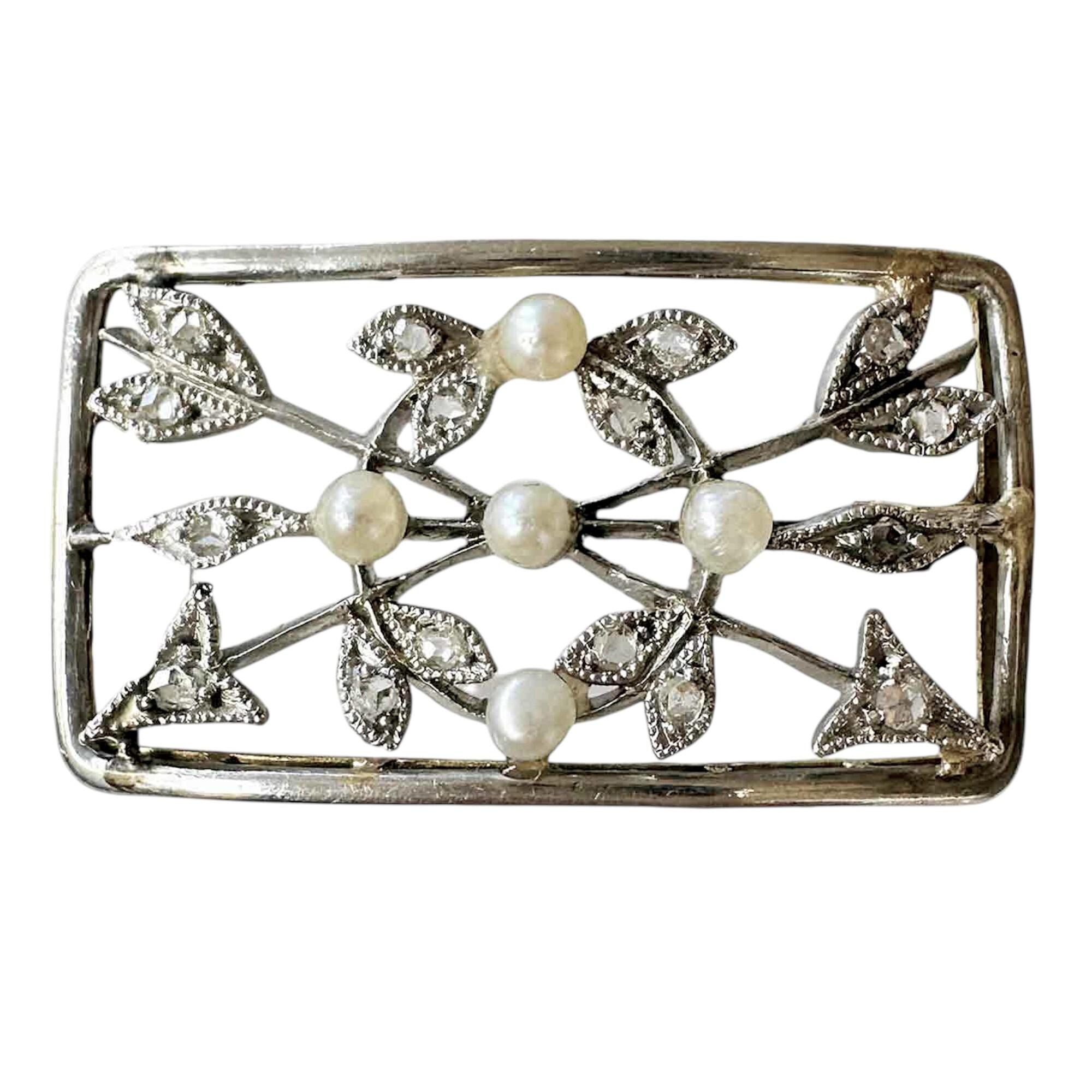 Edwardian brooch in 18ck gold and platinum with diamonds and pearls, featuring diamond arrows on white background