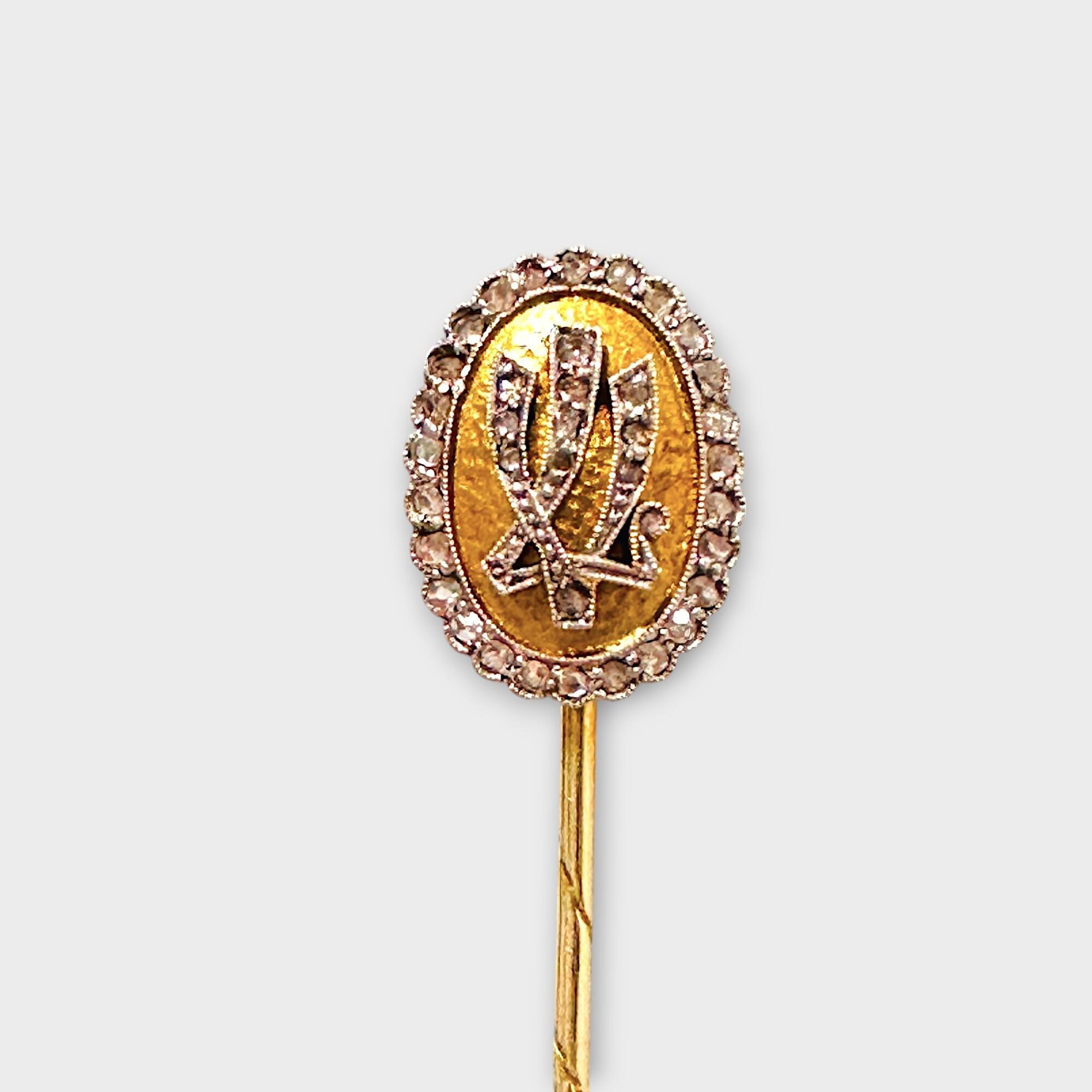 Bespoke 14k gold and diamond monogram LV stick pin with grey background.