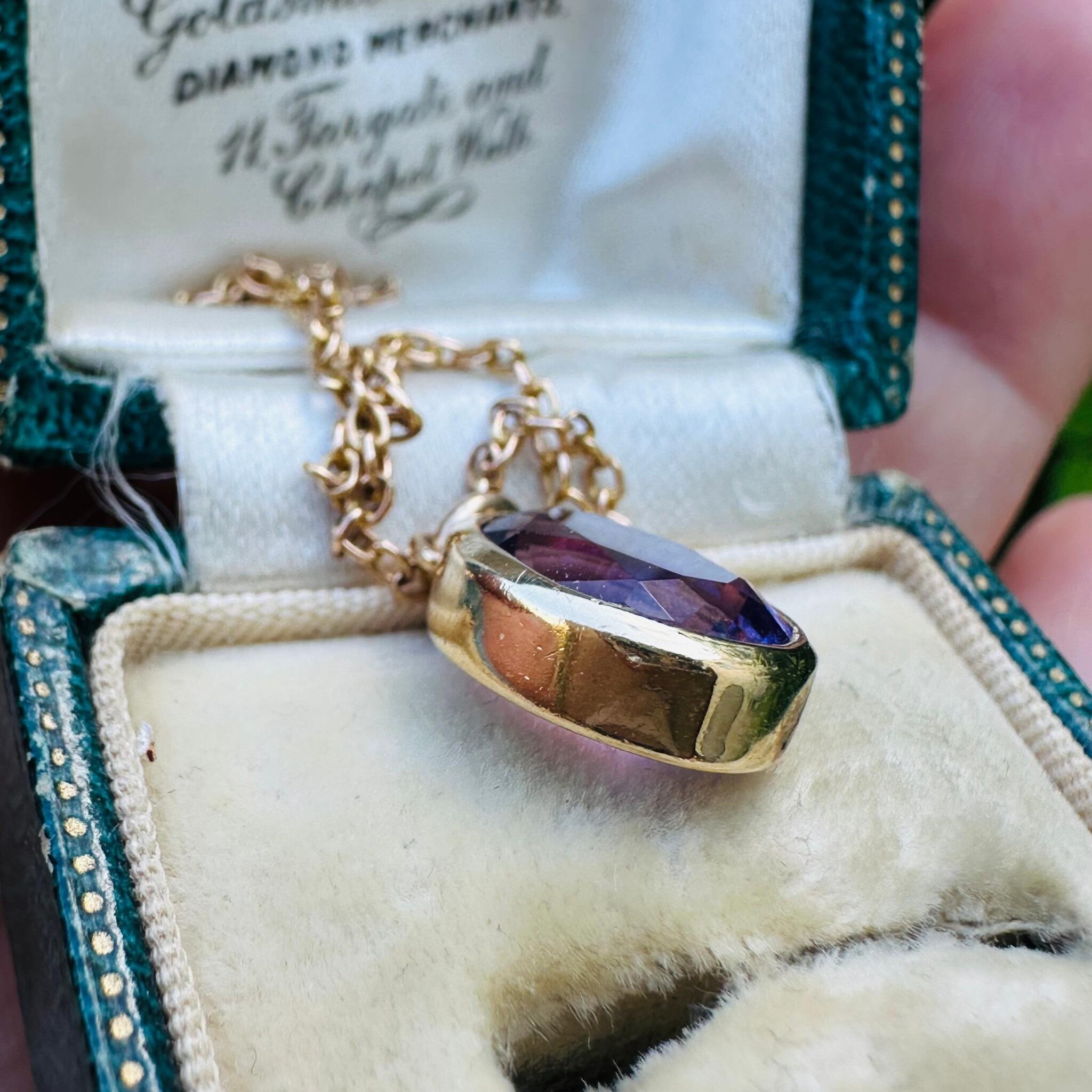 side profile of 14k Yellow Gold & Amethyst Pendant lying in antique box