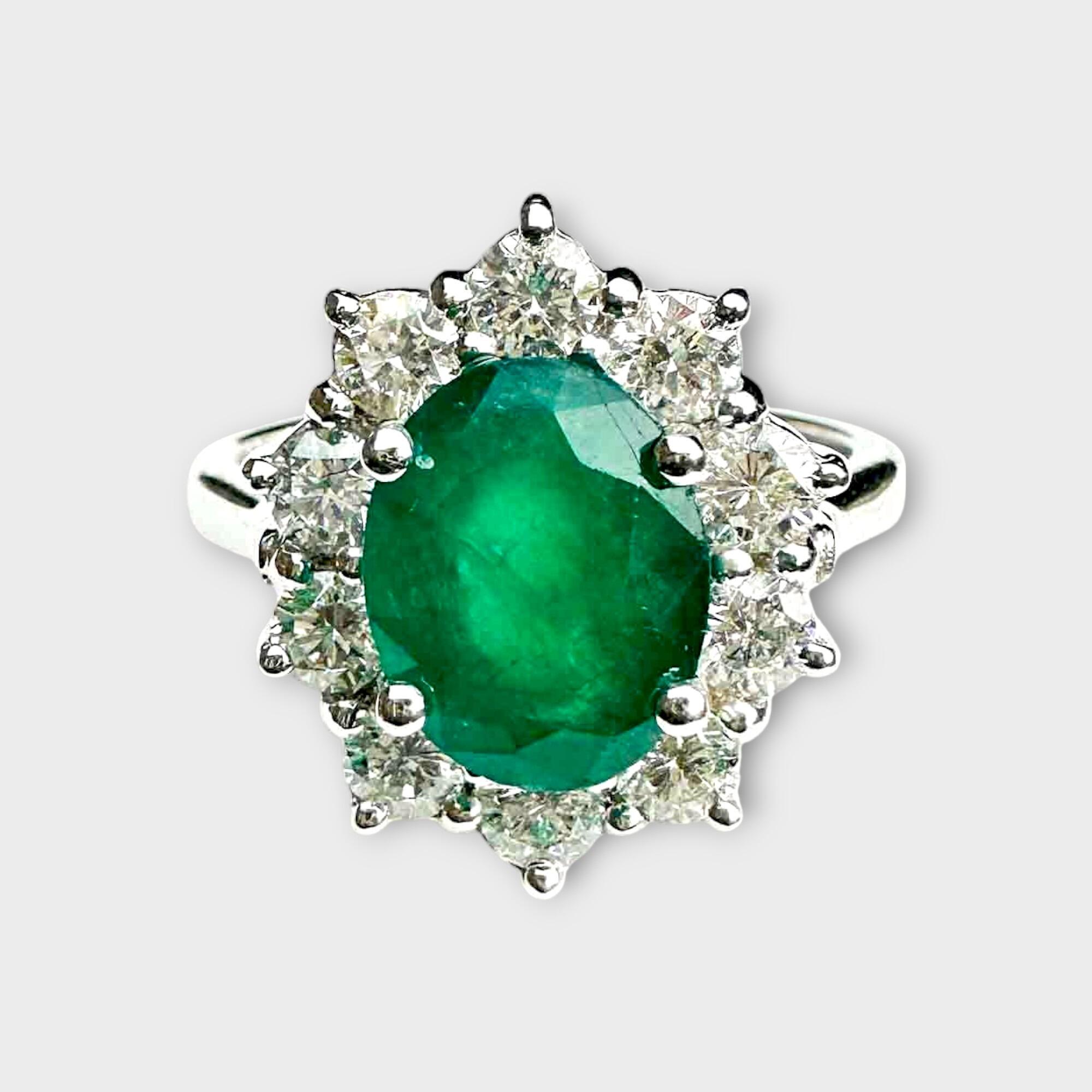 white gold flower cluster ring with central oval emerald and diamond set petals