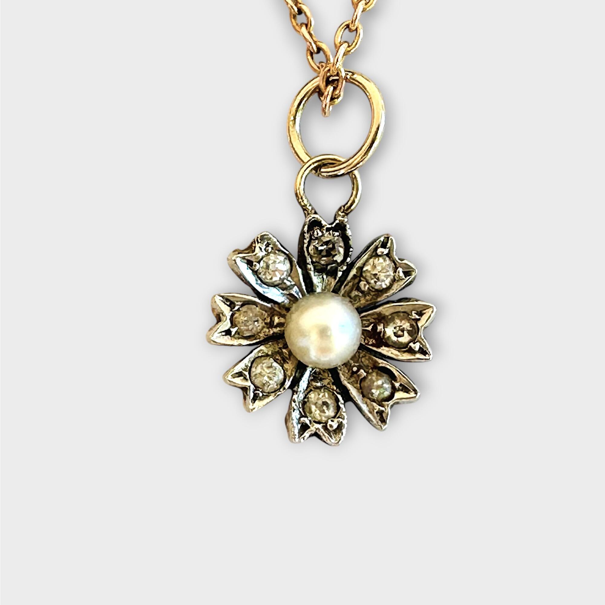 Victorian diamond and pearl daisy charm, pendant on grey background.