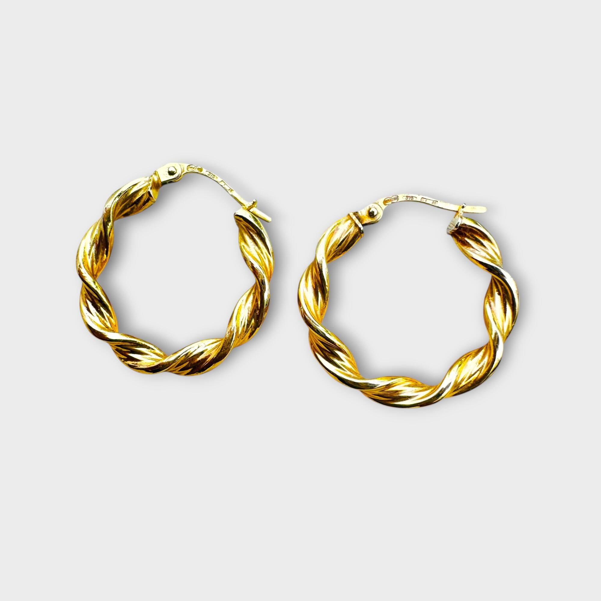 Italian 9k gold twist hoop earrings on grey background.