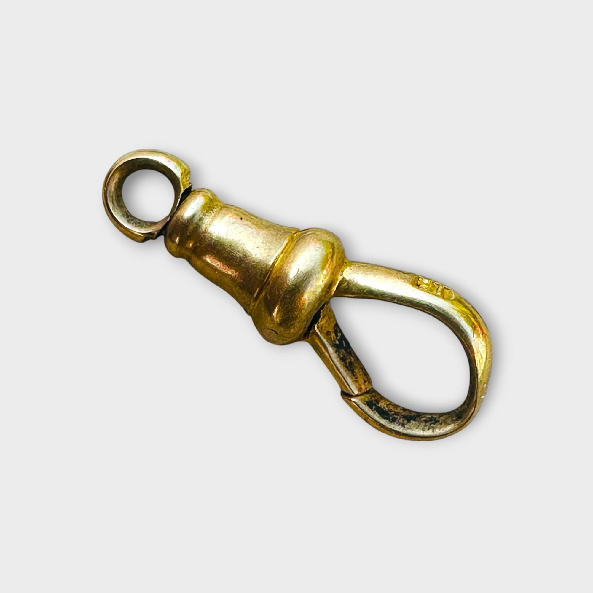 Antique 18ct gold dog clip with swivel mechanism and hallmark “18,” size 17x6.5mm on grey background.