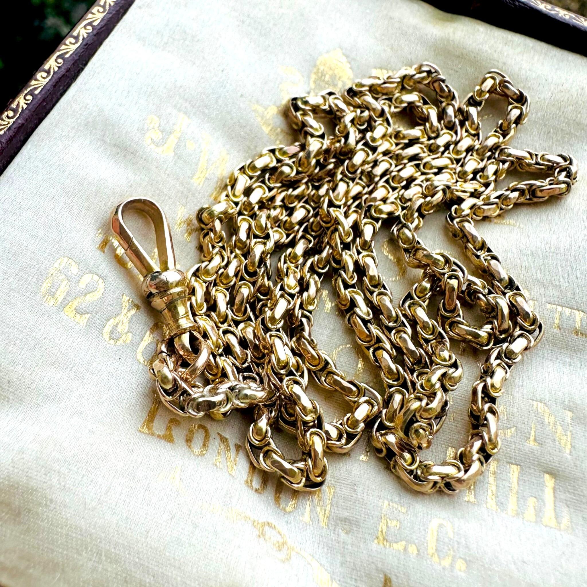 Victorian Gold Fancy Link Long Chain Necklace & Dog Clip  laying on antique box