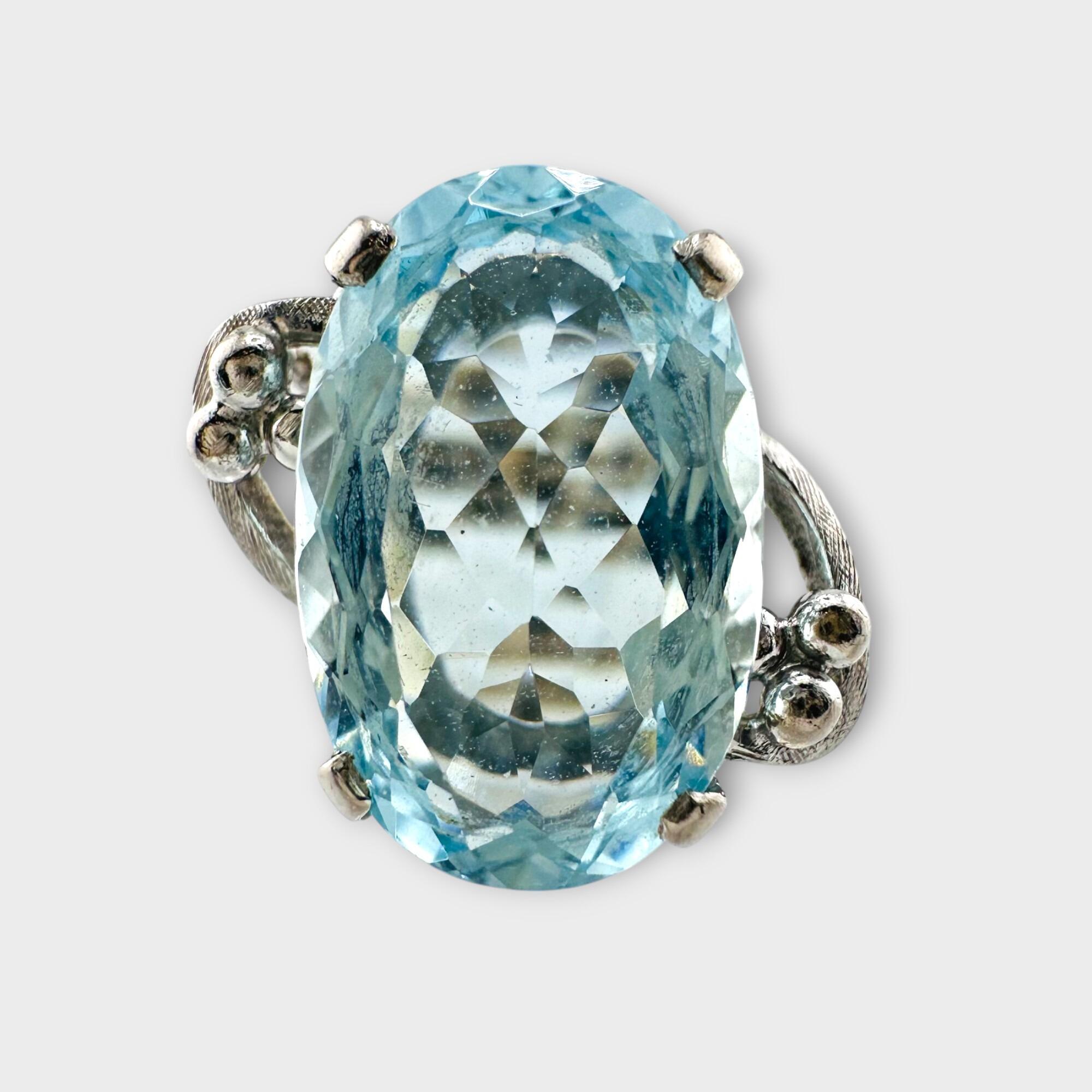 18ct white gold aquamarine cocktail ring on grey background.
