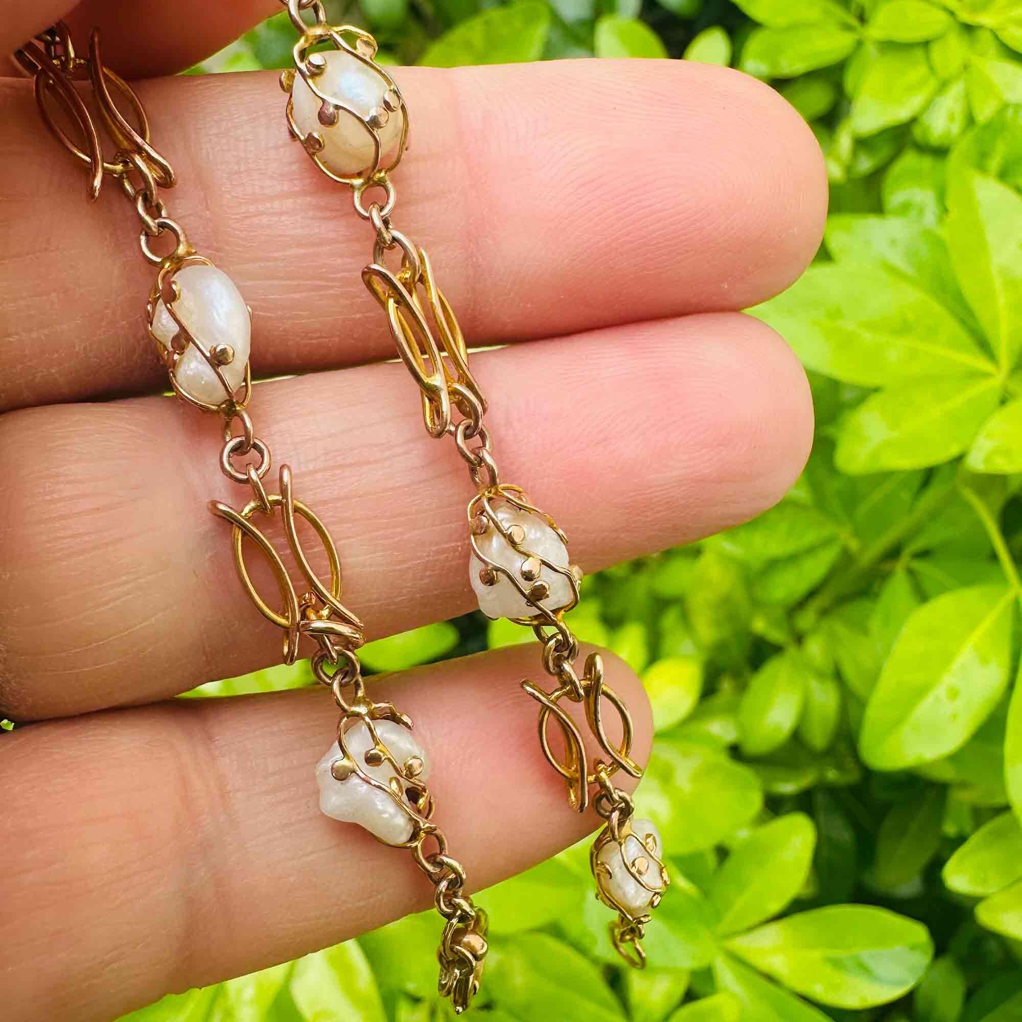 Art nouveau 9k rose gold cage pearl bracelet held in hand in garden