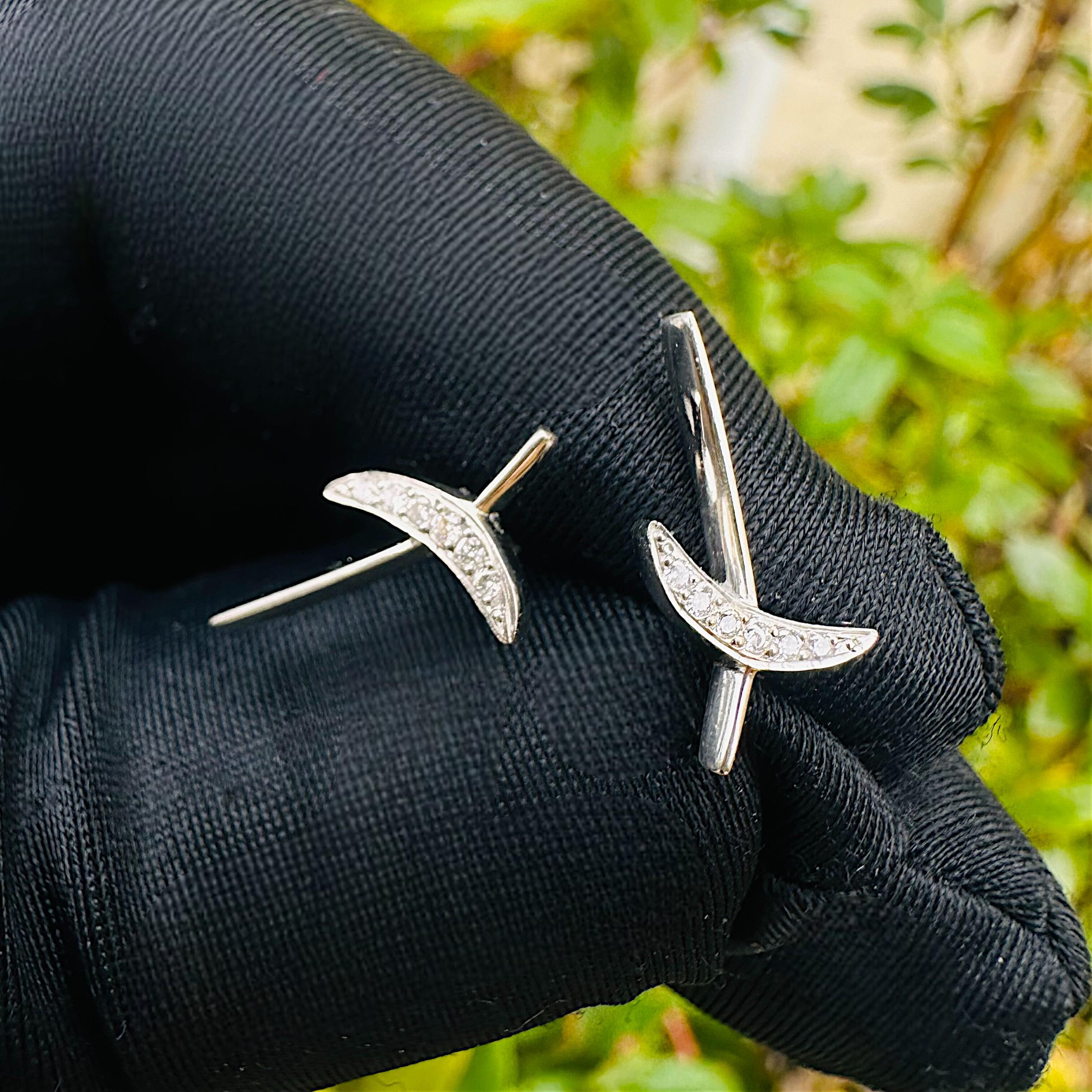 Platinum & Diamond Kiss Earrings held in black glove in garden