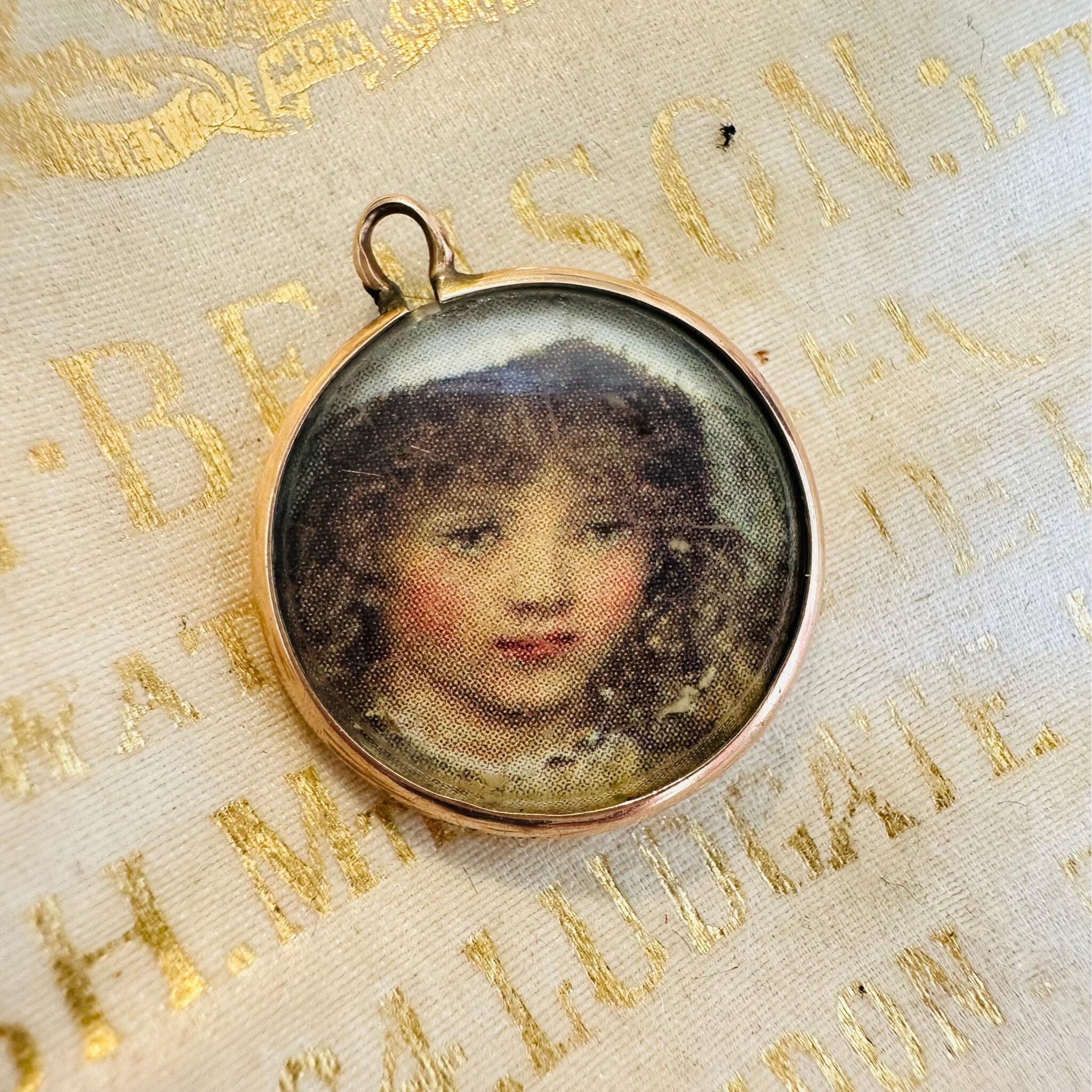Art Nouveau Rose Gold Locket with Portrait  laying on an antique box