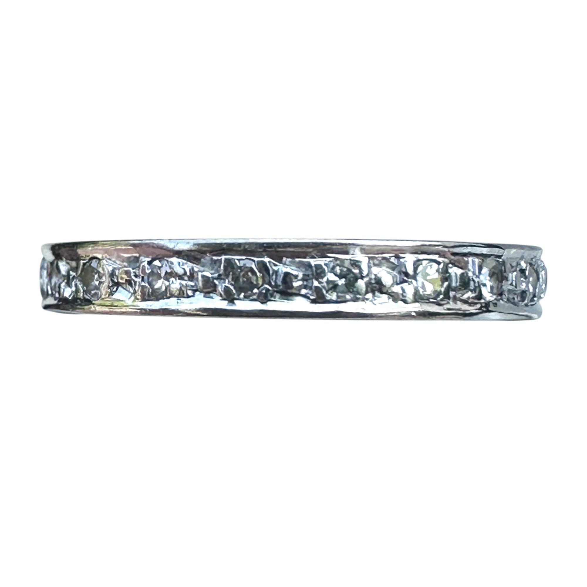 Art Deco full eternity ring in 18ct white gold, set with diamonds all around the band on white background.
