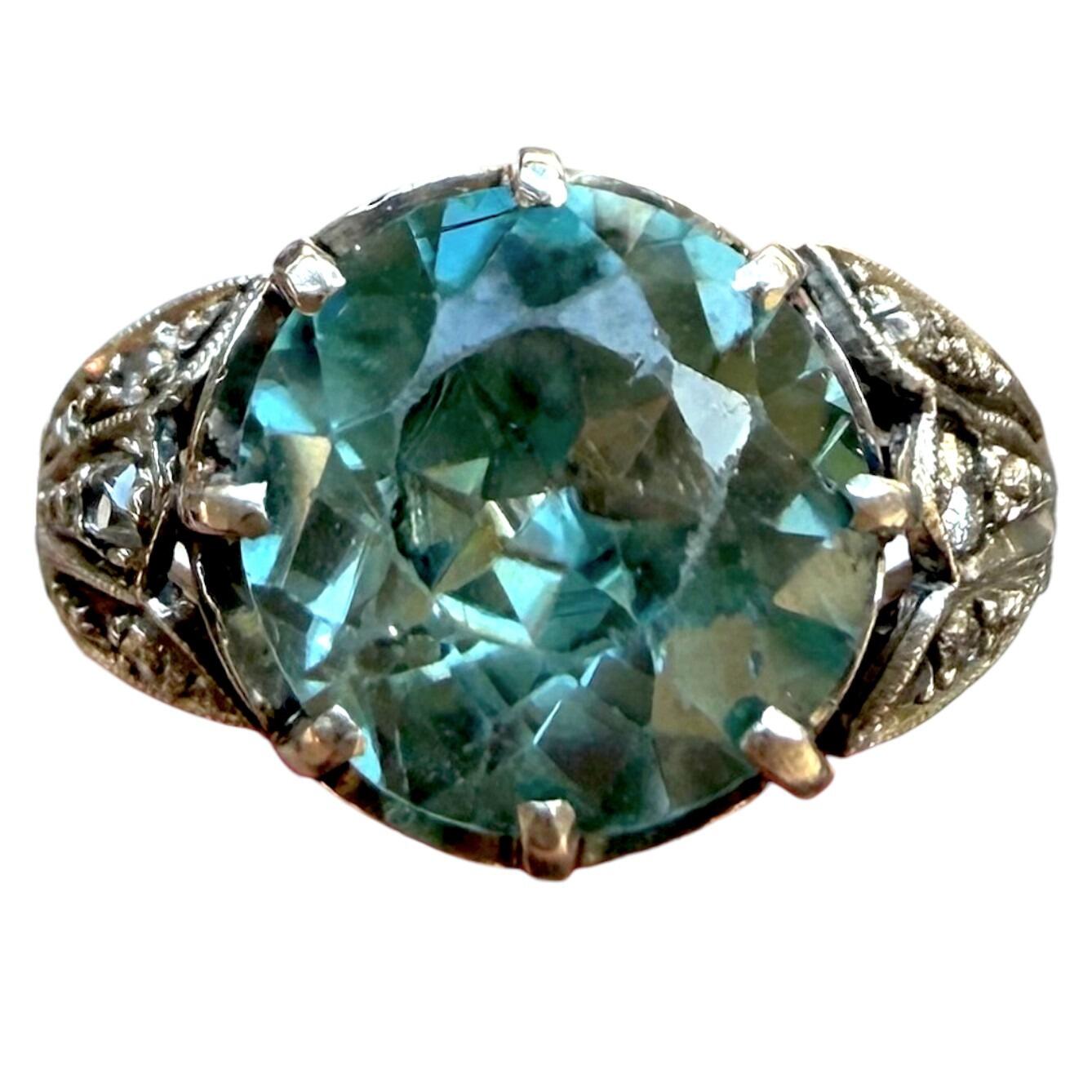 white gold ring with large blue zircon gemstone and diamond studded shoulders