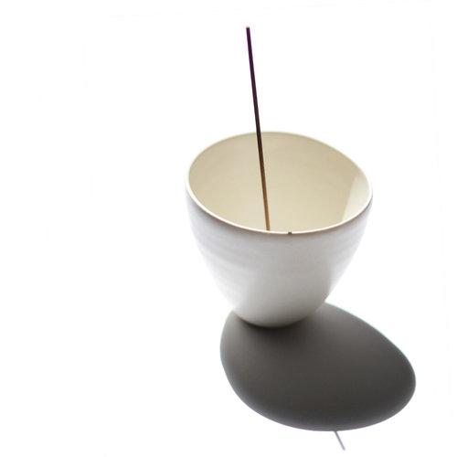 White porcelain curved pot shown with incense stick inserted