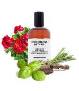 brown plastic bottle surrounded by herbs white label showing amphora invigorating bath oil