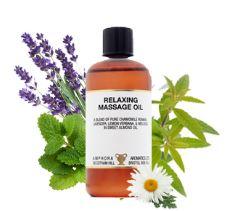 Brown plastic bottle and black cap with white label showing relaxing massage oil, white background with leafs and flowers
