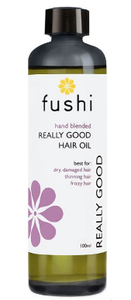 A brown glass bottle with black cap. Natural label has white flower image. Label shows Fushi really good hair oil.