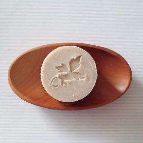 brown wood oval soap dish with round beige soap imprinted with pure nuff stuff leaf logo