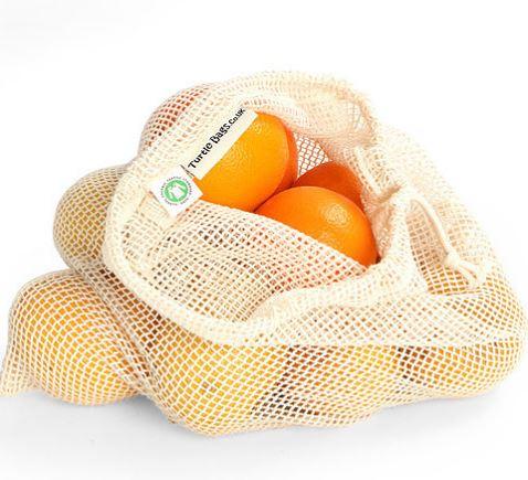 open natural cotton woven net bag with draw string. Filled with oranges.
