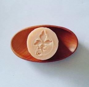 brown wooden oval soap dish with white round bar of soap imprinted with pure nuff stuff leaf logo