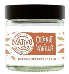 A clear glass jar with black cap, contains white balm. White label with brown text shows native unearthed vanilla and coconut deodorant balm.