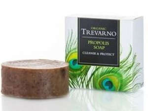 brown round soap, white square box with green feathers, green writing trevarno organic propolis soap