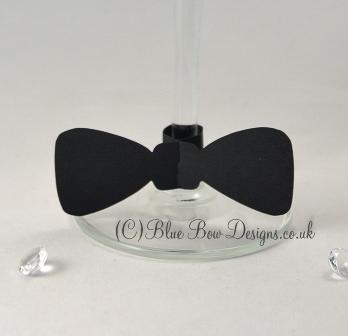 Black card bow tie place card on stem of wine glass
