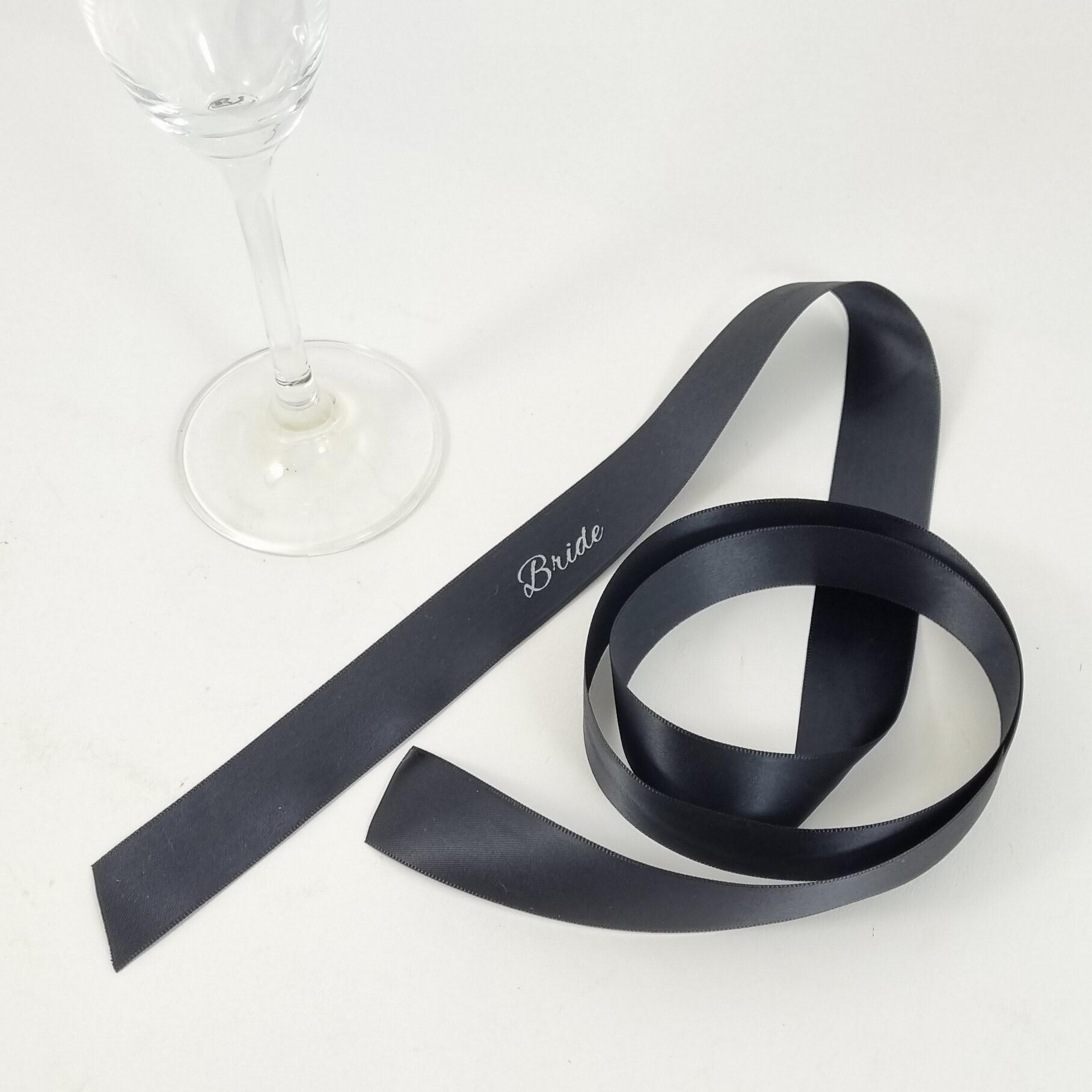 Black and white napkin ribbon bow with long tails and printed guest names on ribbon for weddings