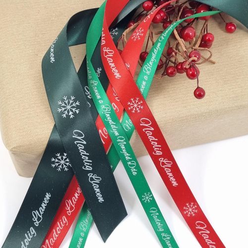 Nadolig Llawen welsh words printed on ribbons for Christmas. Red and white print