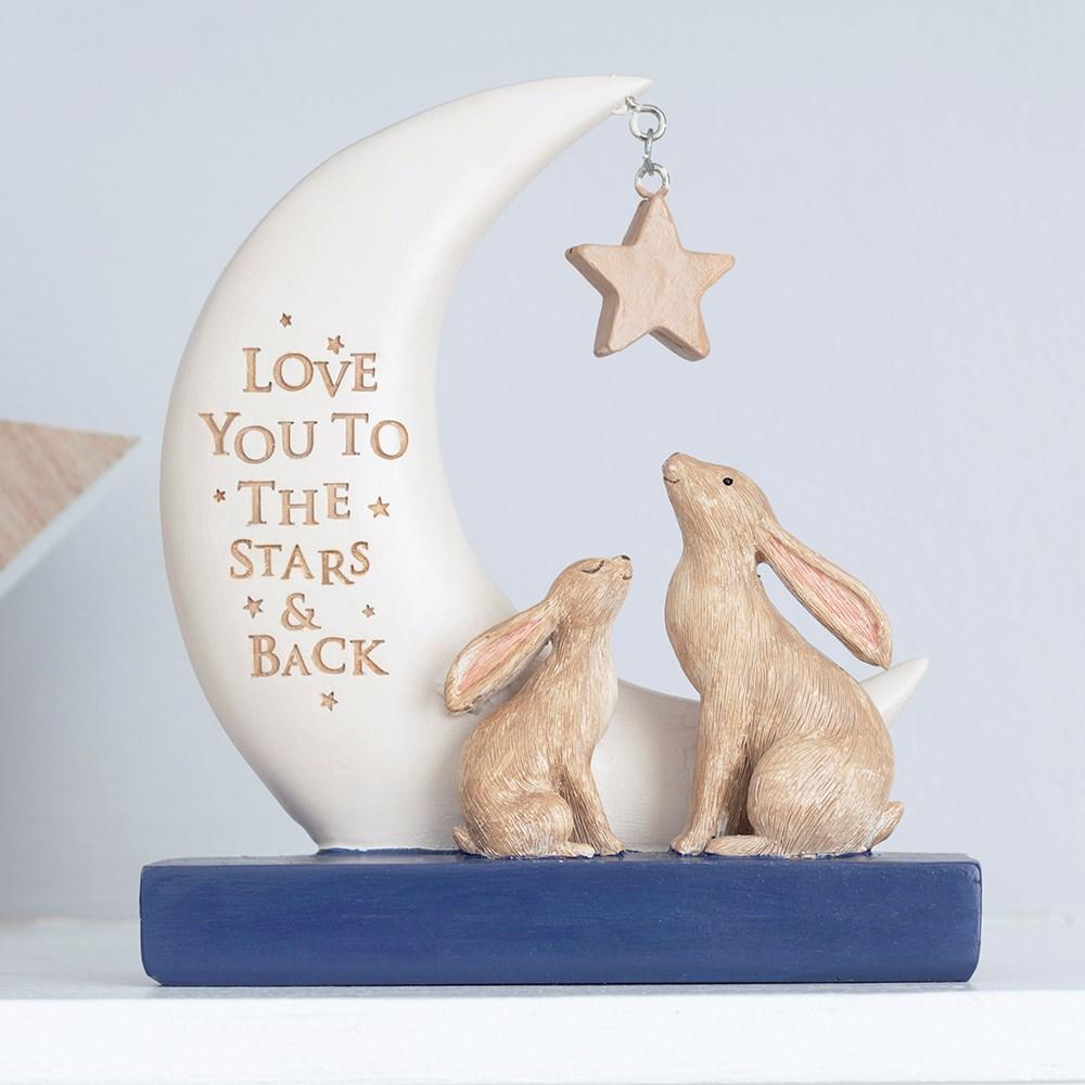 Navy and white resin ornament with two rabbits, stars and a moon that reads 'Love you to the stars & back', on a white shelf.