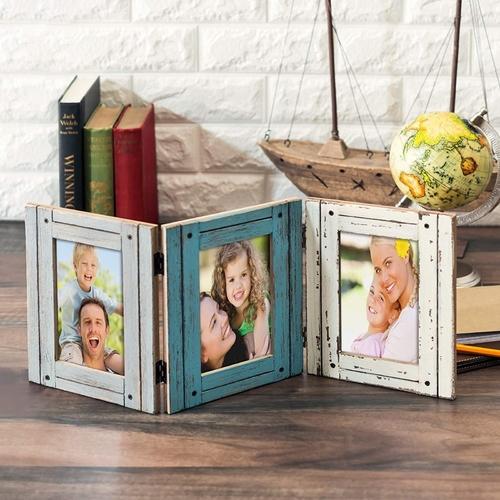 Hinged triple rustic photo frame holding family pictures, displayed on a wooden table with a white stone background.