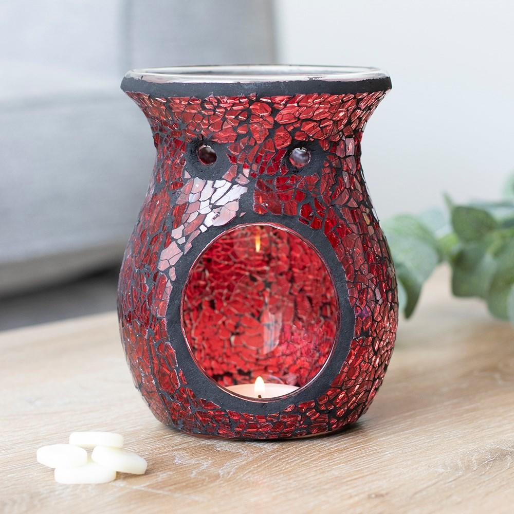Large oil burner or wax melt burner with a red crackle effect and a sparkle when it catches the light, on a wooden surface.