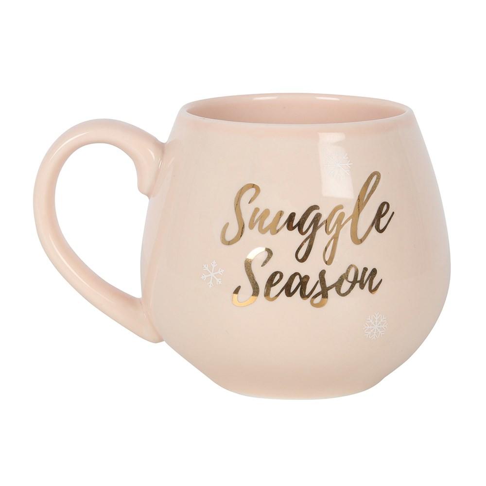 Pink ceramic Christmas mug with rose gold 'Snuggle Season' text and snowflakes.