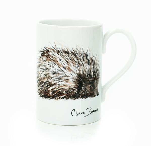 A white porcelain mug with a hand painted hedgehog on the front, handmade by Clare Baird.