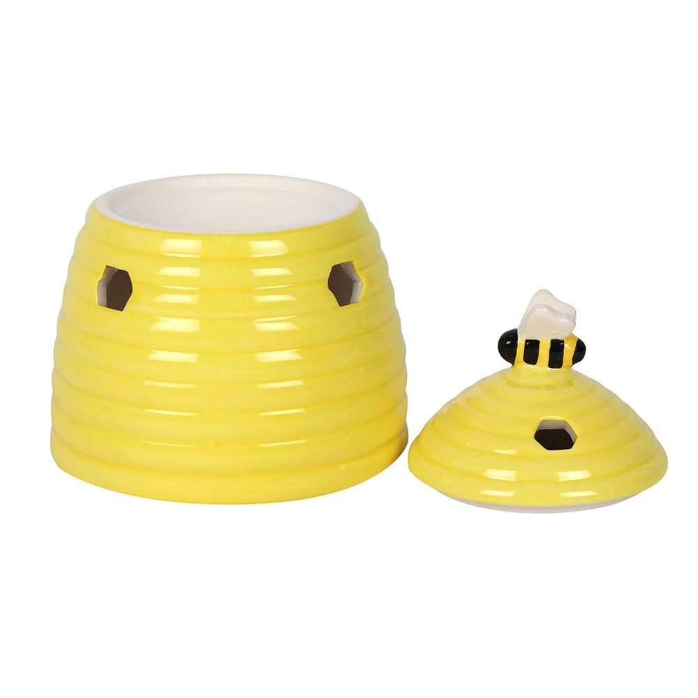 Yellow ceramic oil burner & wax warmer in shape of a beehive with a bee on the lid & honeycomb shaped cutouts, lid removed.