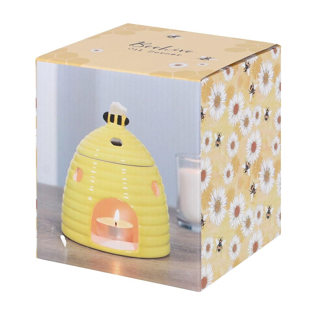 Yellow ceramic oil burner & wax warmer in shape of a beehive with a bee on the lid & honeycomb shaped cutouts, shown in box.