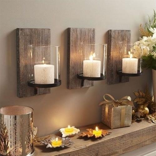 Set of three rustic candle holders with wooden backs and wrought iron holders, above a decorated wooden fireplace mantle.
