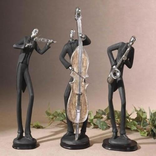 Three tall jazz player figurines dressed in black, one with a saxaphone, one with a bass guitar and one with a violin.