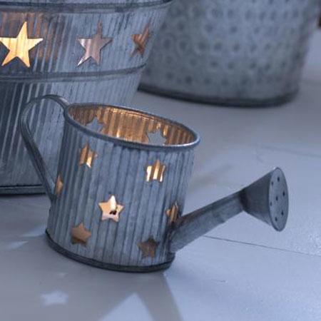 Star tin watering can shaped tealight holder, shown with a lit tealight and other star tin items.