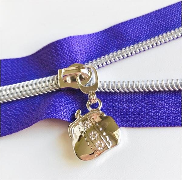 silver handbag shaped zipper pull on purple zipper tape