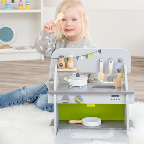 Child playing with toy kitchen