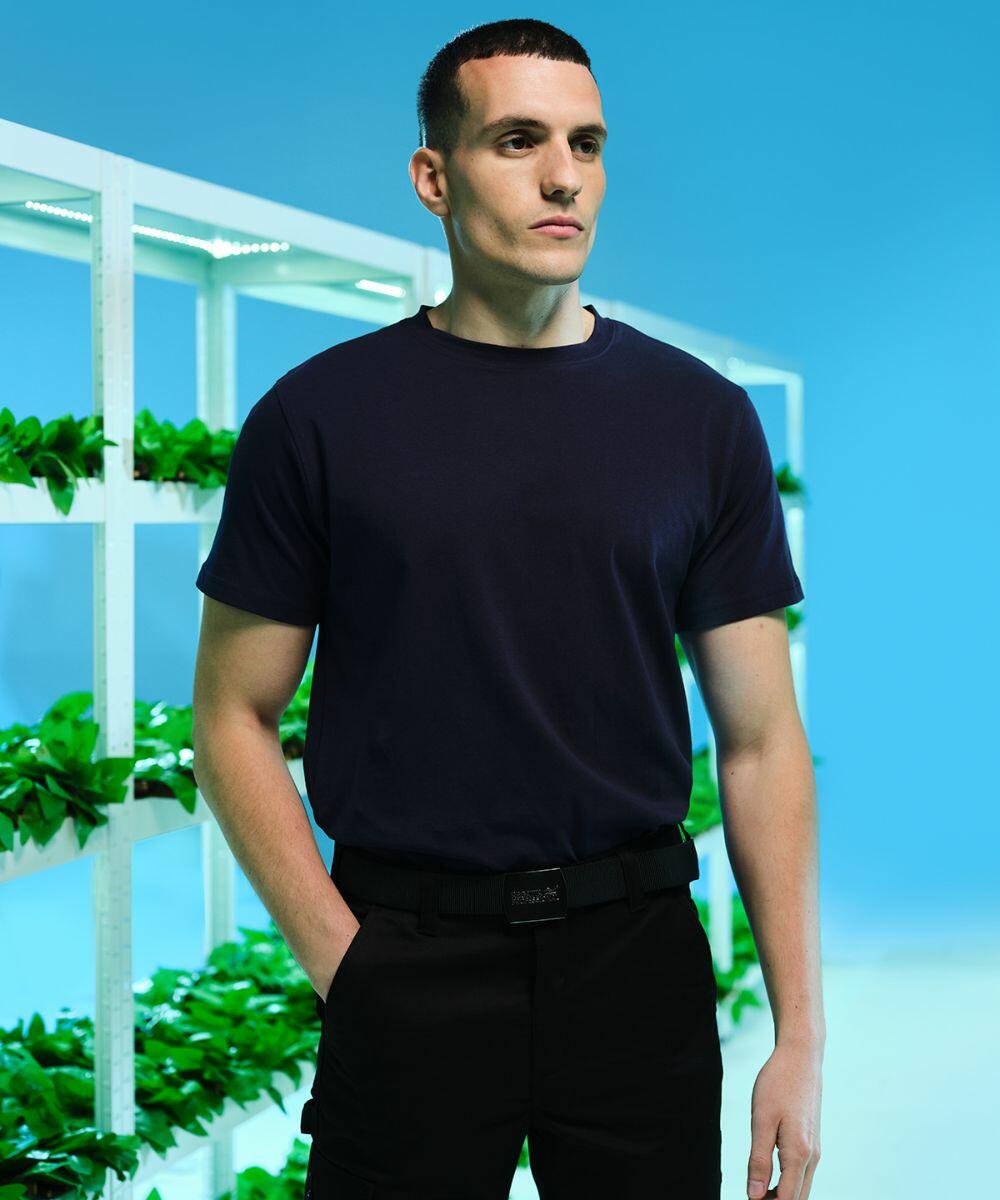 A man in a dark blue T-shirt stands in front of Regatta RG618 vertical hydroponic plant racks against a blue background.