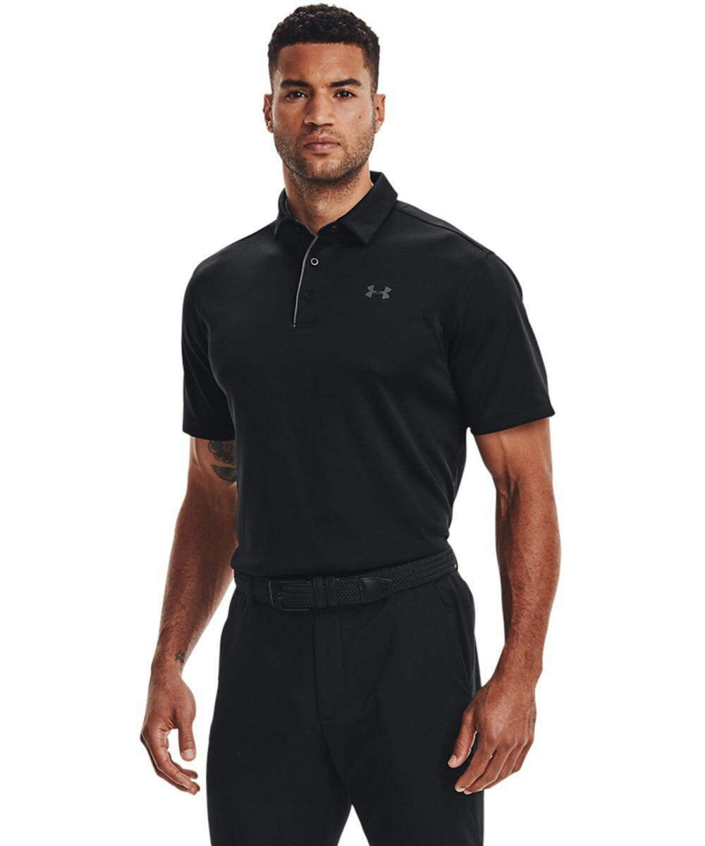 A man wearing a black Under Armour UA043 short-sleeve polo shirt and black pants stands facing forward.