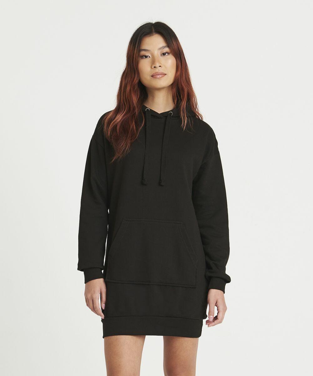 A person wearing an AWDis Just Hoods JH015 black hoodie dress with a front pocket and drawstring hood, standing against a plain white background.