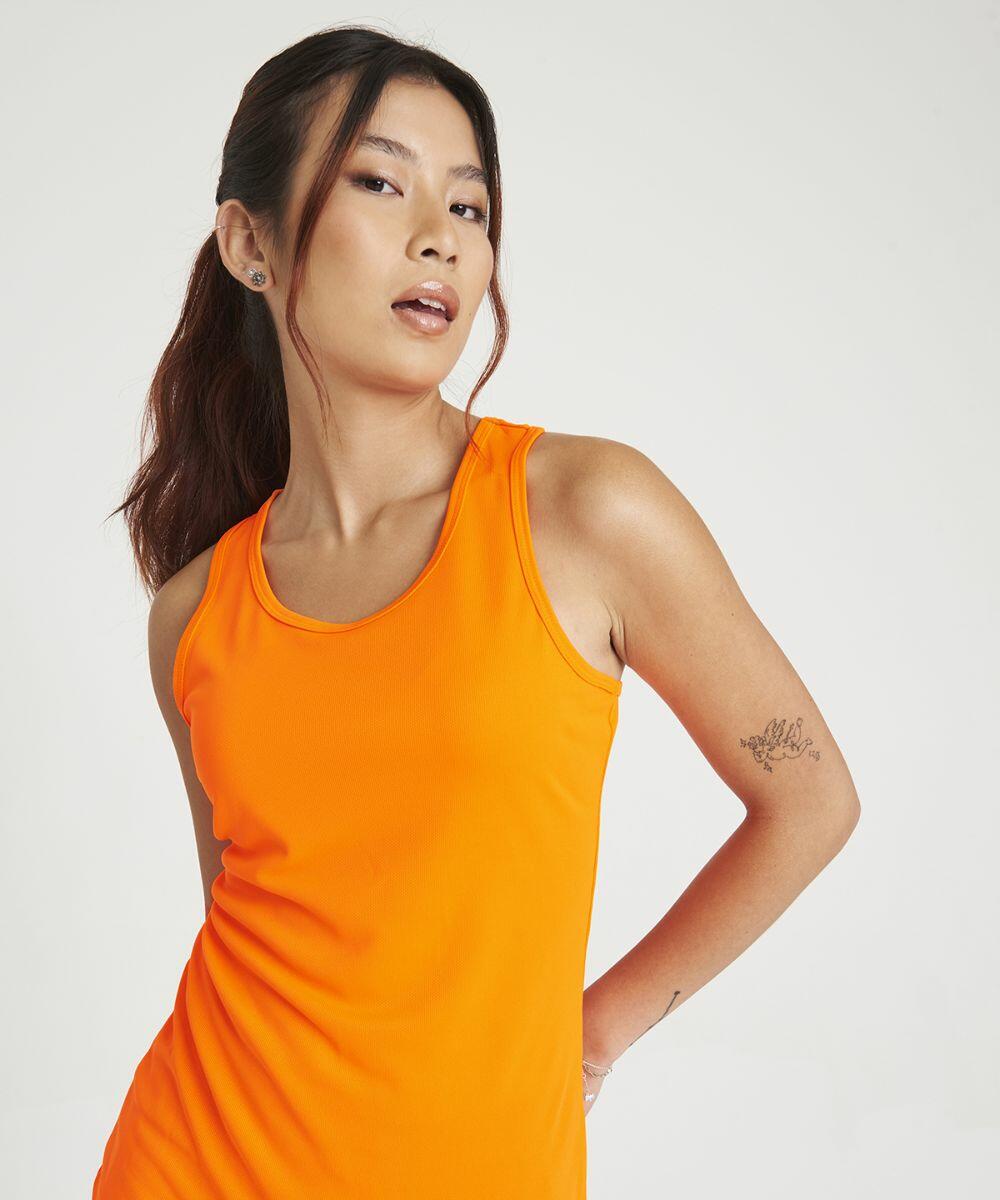 Person wearing an orange sleeveless JC015 by AWDis Just Cool standing against a plain background.