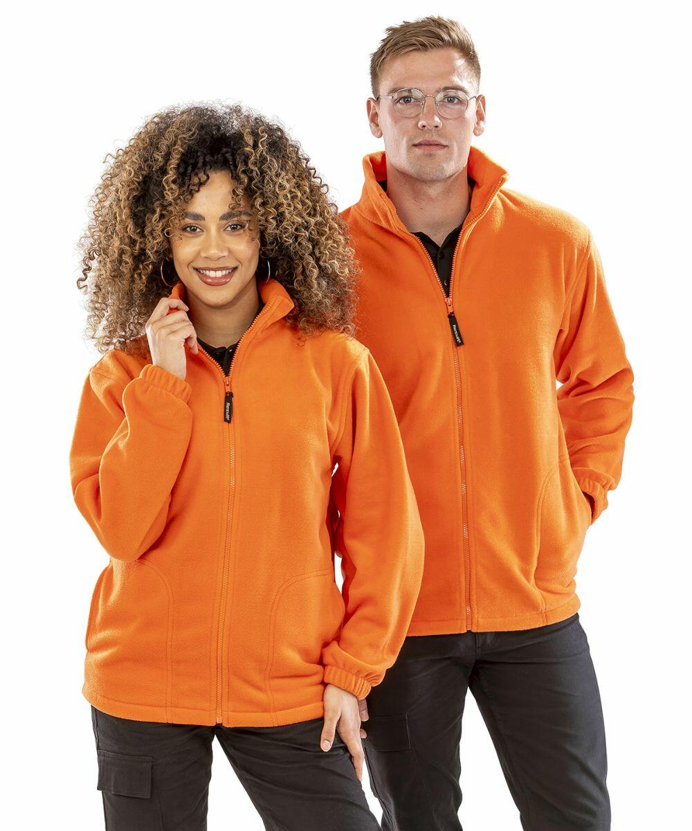 Two people wearing bright orange Result RE36A fleece jackets, standing side by side; the person on the left has curly hair and the person on the right is wearing glasses.