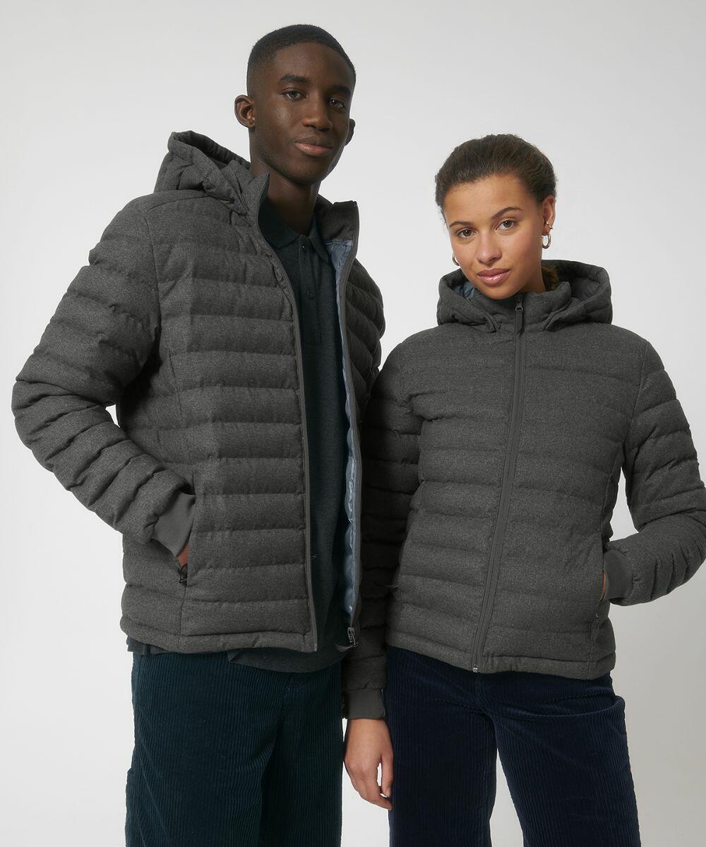 Two people stand close together, both wearing grey SX201 hooded puffer jackets from Stanley/Stella. The person on the left has hands in pockets, while the person on the right has hands by their sides. The background is plain white.