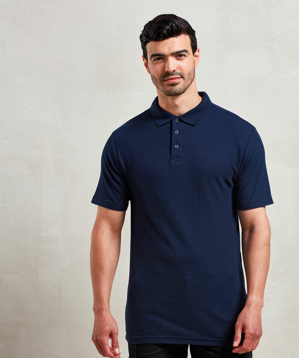 A person standing against a plain background, wearing a Premier PR610 navy blue polo shirt.