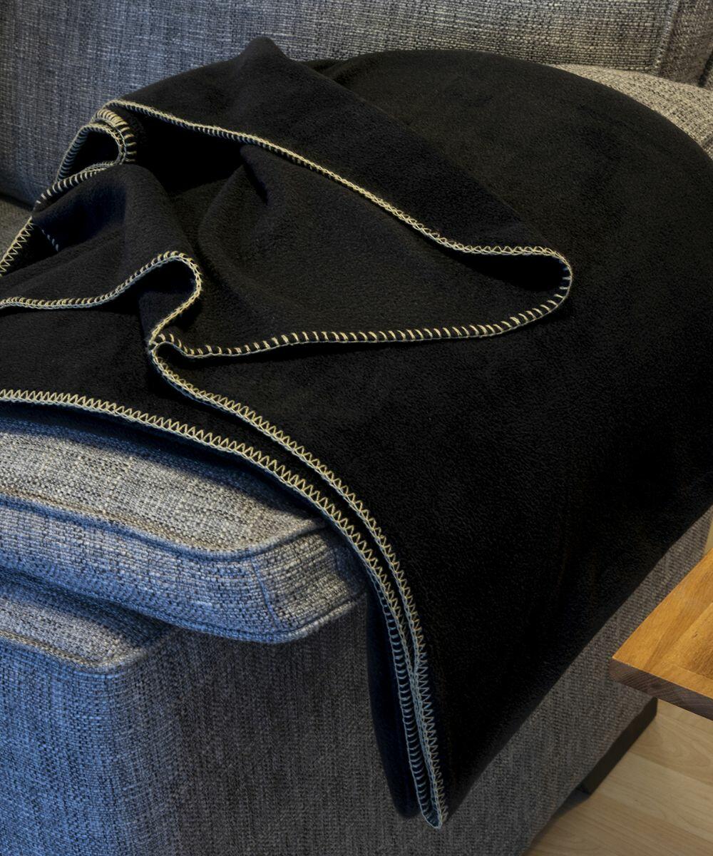 Black Result RE39A with a zigzag trim draped over the arm of a gray couch.