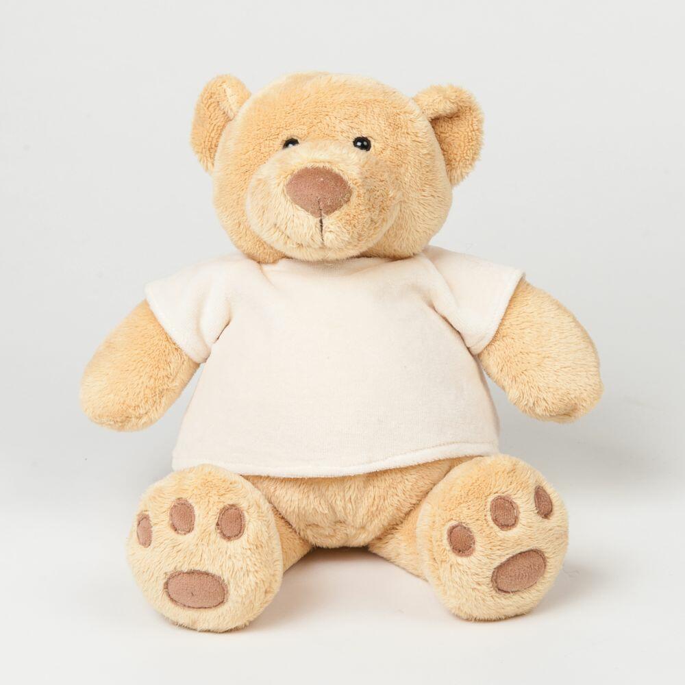 A plush teddy bear designed by Mumbles, featuring light brown fur and wearing a white shirt, is sitting upright against a plain background. Model number: MM021.